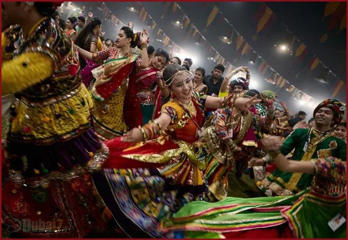 Devotees in Gujarat celebrating Navratri with Garba and Dandiya Raas, wearing vibrant traditional outfits and dancing in large circles.